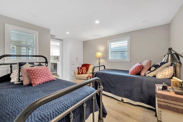 bedroom featuring light hardwood / wood-style flooring and ensuite bathroom