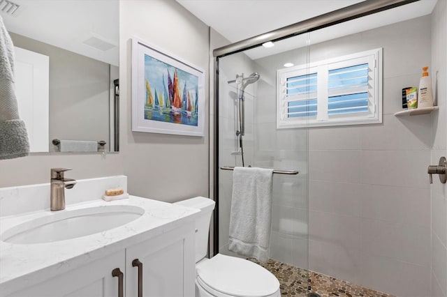 bathroom featuring vanity, an enclosed shower, and toilet