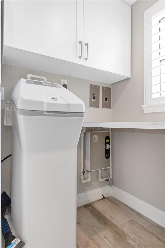 laundry room with light hardwood / wood-style floors and cabinets