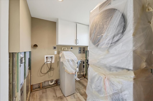 clothes washing area with cabinets, light hardwood / wood-style floors, hookup for a washing machine, and electric dryer hookup