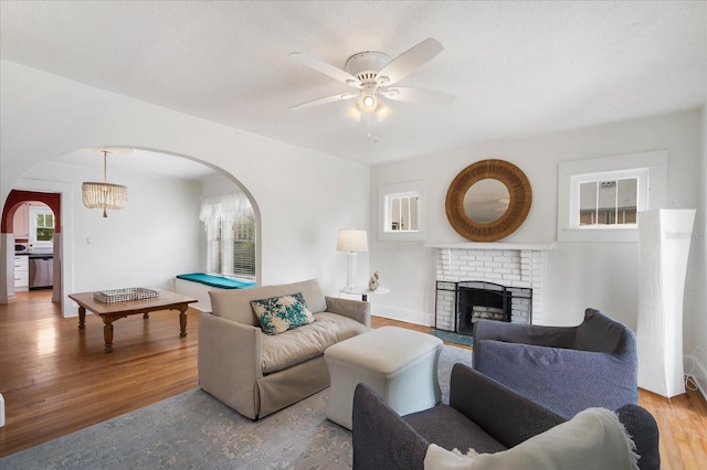 living room with a fireplace, light hardwood / wood-style floors, and ceiling fan