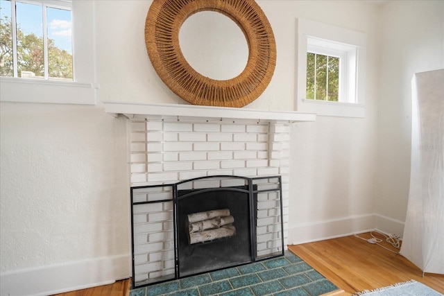 interior details featuring a brick fireplace and hardwood / wood-style floors