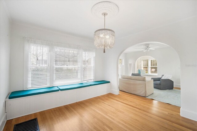 interior space featuring ceiling fan with notable chandelier and hardwood / wood-style floors