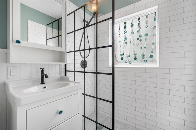 bathroom with vanity and tiled shower