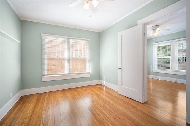 spare room with crown molding, light hardwood / wood-style floors, and ceiling fan