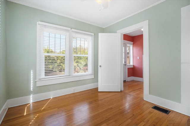 unfurnished room with hardwood / wood-style flooring, ornamental molding, and ceiling fan