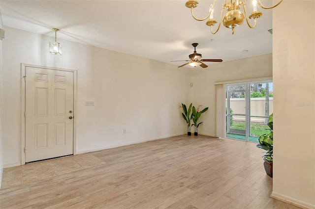 interior space with light wood-type flooring, baseboards, and ceiling fan with notable chandelier