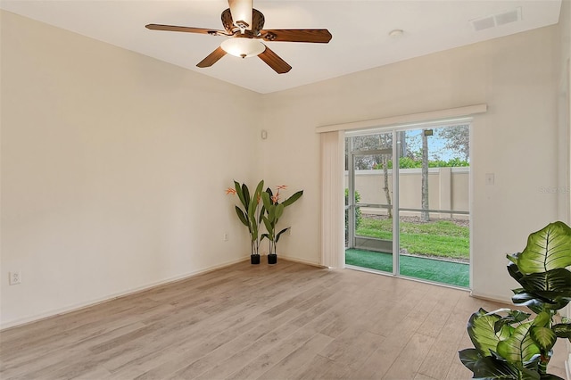 unfurnished room featuring light wood-type flooring, ceiling fan, visible vents, and baseboards