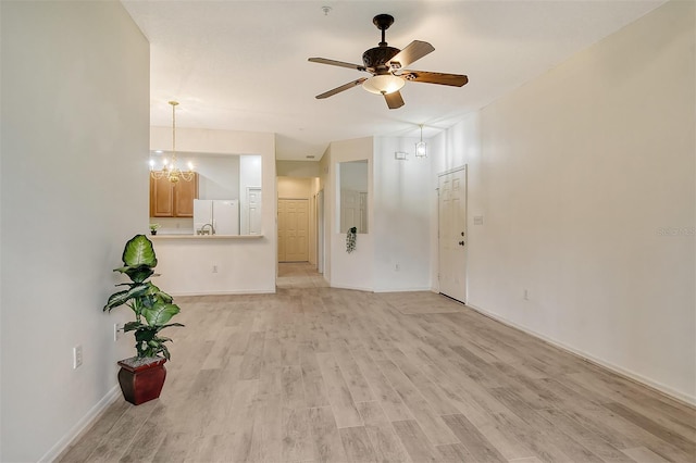 unfurnished living room with light wood-style floors, baseboards, and ceiling fan with notable chandelier