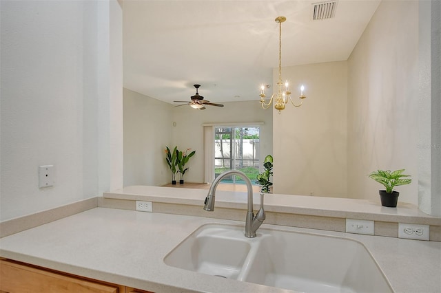 kitchen with a sink, visible vents, light countertops, hanging light fixtures, and an inviting chandelier