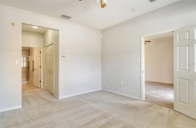 unfurnished room with baseboards, visible vents, a ceiling fan, and light colored carpet