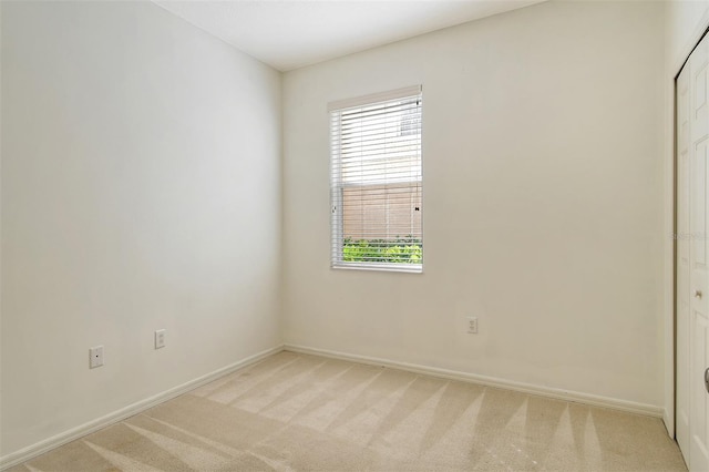 empty room with light colored carpet, plenty of natural light, and baseboards