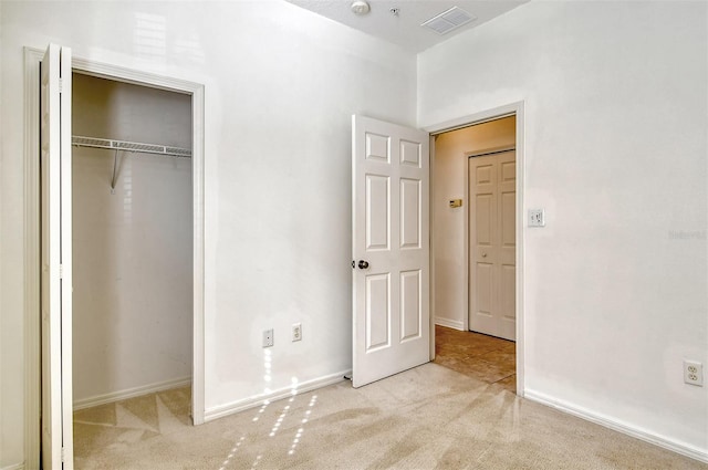 unfurnished bedroom featuring a closet, carpet flooring, visible vents, and baseboards