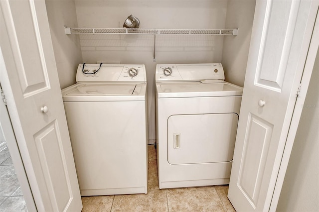 washroom featuring laundry area, independent washer and dryer, and light tile patterned floors