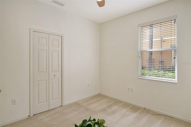 unfurnished room with ceiling fan, baseboards, visible vents, and light colored carpet