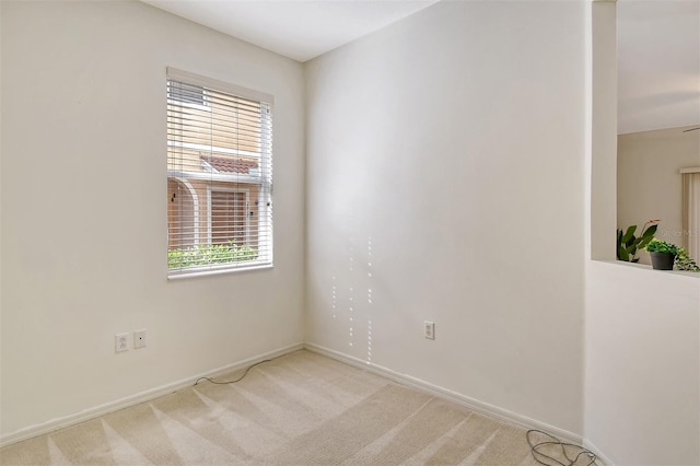 empty room with baseboards and light colored carpet