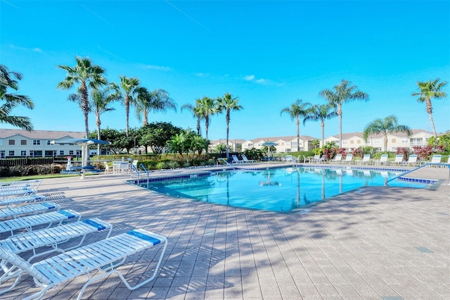 community pool with a residential view and a patio area