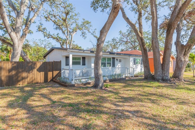 rear view of property with a porch and a yard