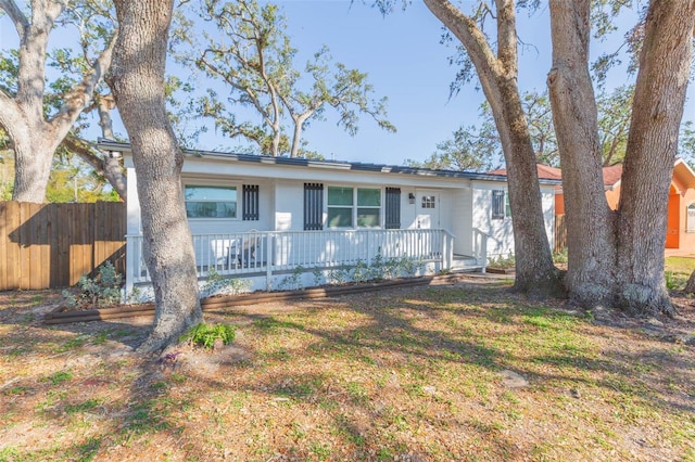 ranch-style home with a front yard and covered porch