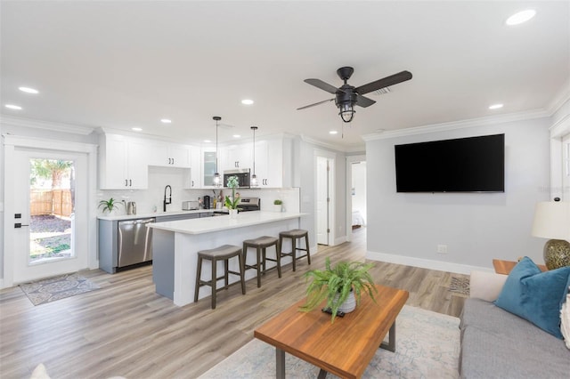 living room with crown molding, sink, ceiling fan, and light hardwood / wood-style flooring