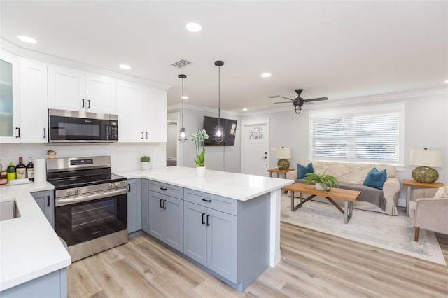 kitchen featuring white cabinetry, stainless steel appliances, kitchen peninsula, and hanging light fixtures