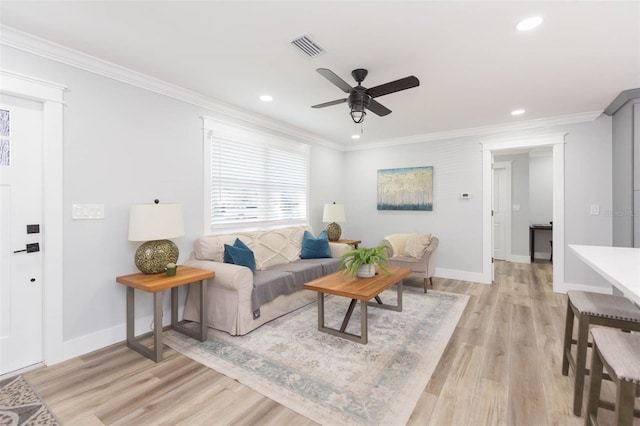 living room with crown molding, ceiling fan, and light wood-type flooring