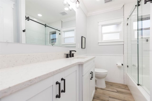 full bathroom with a healthy amount of sunlight, wood-type flooring, ornamental molding, and toilet