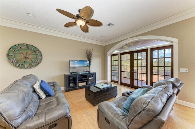 living room with ceiling fan, light hardwood / wood-style floors, ornamental molding, a textured ceiling, and french doors