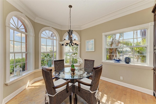 dining space with a notable chandelier, crown molding, and light wood-type flooring