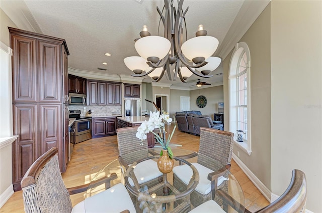 dining area with crown molding, light hardwood / wood-style flooring, a textured ceiling, and a chandelier