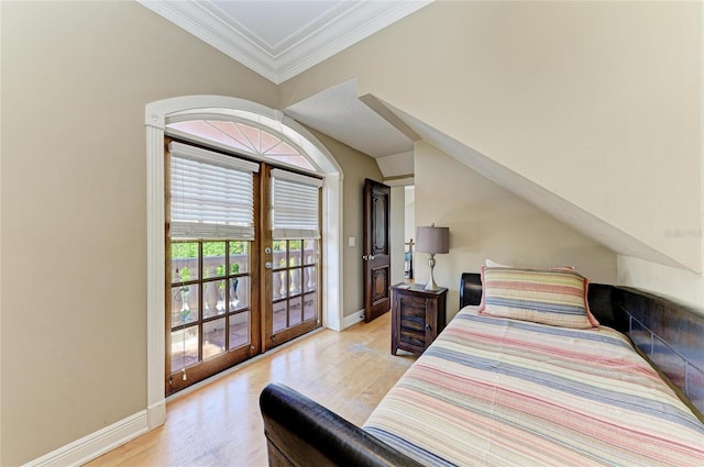 bedroom featuring lofted ceiling, access to exterior, ornamental molding, french doors, and light wood-type flooring