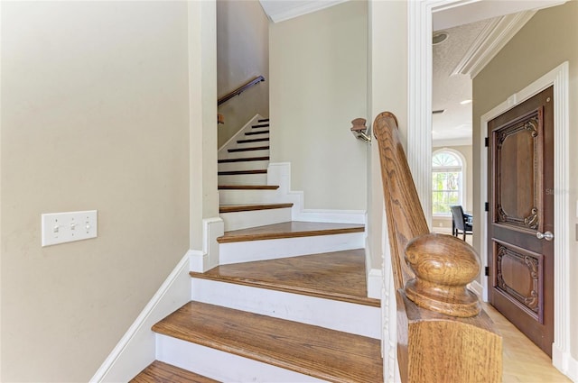 stairway featuring crown molding and hardwood / wood-style flooring