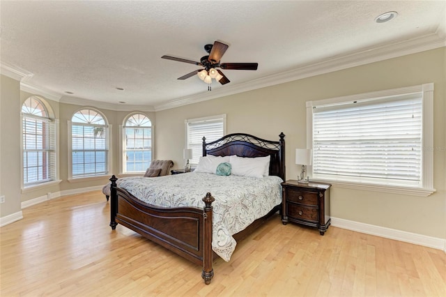 bedroom featuring ornamental molding, light hardwood / wood-style flooring, and a textured ceiling