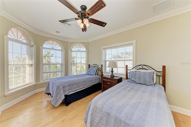 bedroom with crown molding, ceiling fan, and light hardwood / wood-style floors