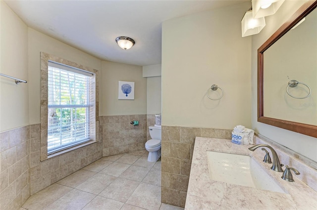 bathroom with tile patterned floors, toilet, tile walls, and vanity