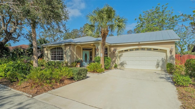 ranch-style house featuring concrete driveway, fence, a garage, and stucco siding