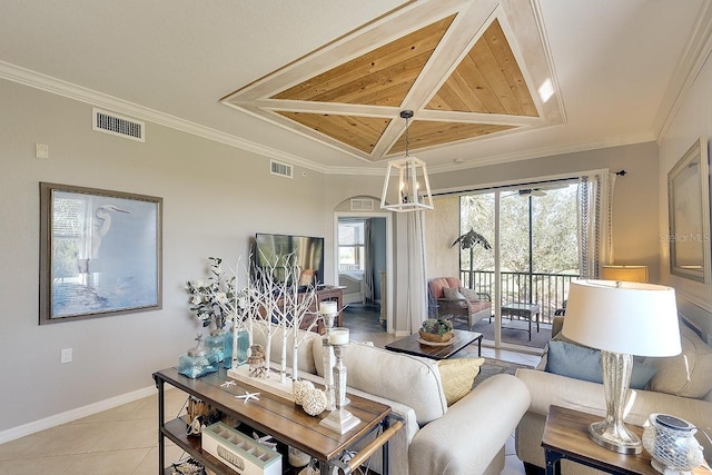 tiled living room with ornamental molding, a tray ceiling, and a chandelier