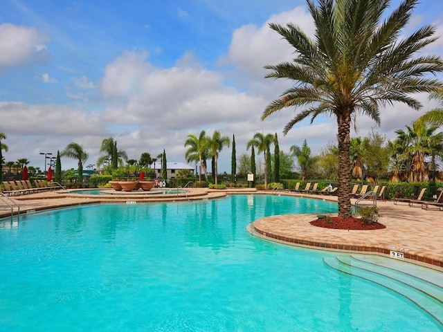 view of pool with a hot tub and a patio