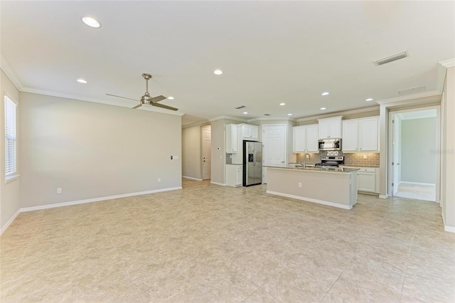 kitchen featuring crown molding, stainless steel appliances, tasteful backsplash, white cabinets, and a center island with sink