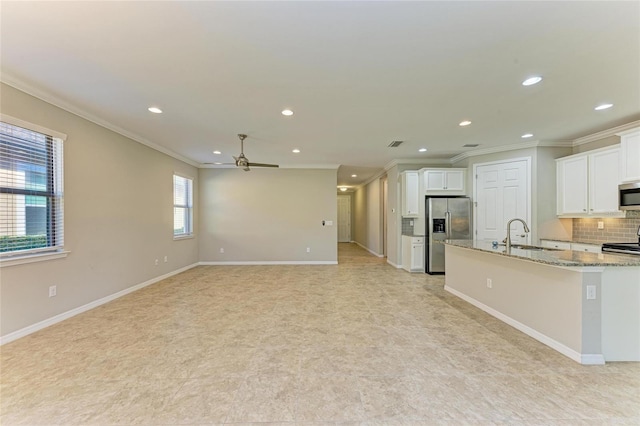 kitchen with light stone counters, sink, stainless steel appliances, and white cabinets