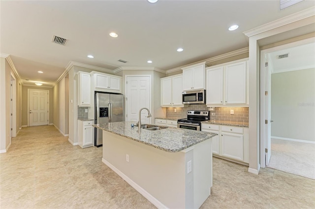 kitchen with white cabinetry, appliances with stainless steel finishes, sink, and a kitchen island with sink