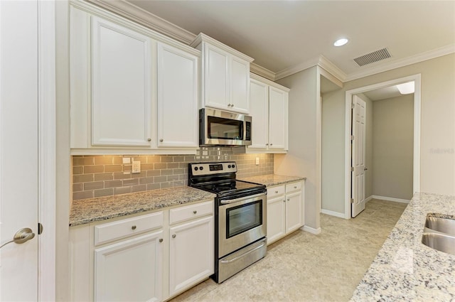 kitchen with light stone counters, stainless steel appliances, backsplash, and white cabinets