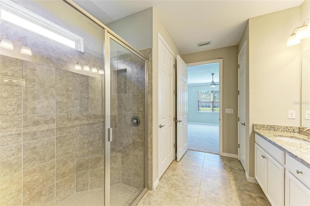 bathroom featuring tile patterned flooring, vanity, and a shower with shower door