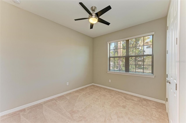 carpeted spare room featuring ceiling fan