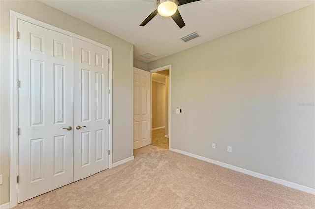 unfurnished bedroom featuring light carpet, a closet, and ceiling fan