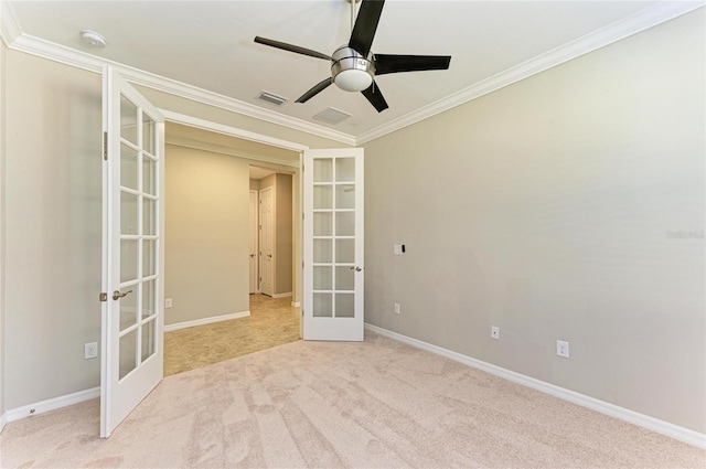 carpeted spare room featuring french doors, ceiling fan, and crown molding