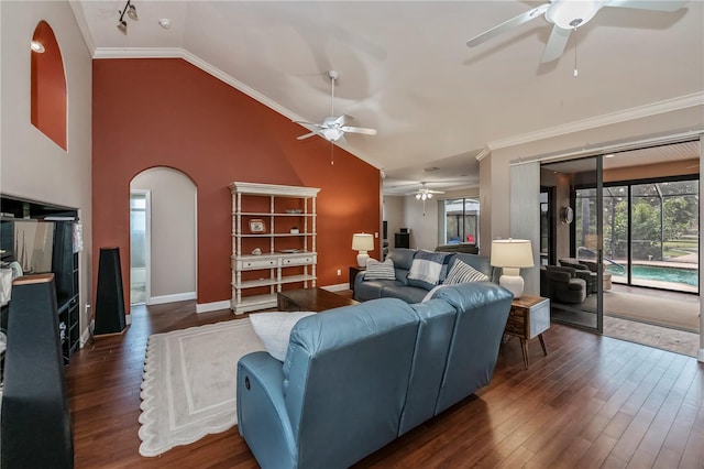 living room with ornamental molding, high vaulted ceiling, dark wood-type flooring, and ceiling fan