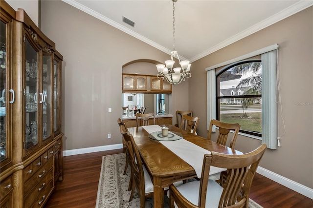 dining space featuring crown molding, lofted ceiling, dark hardwood / wood-style flooring, and a notable chandelier