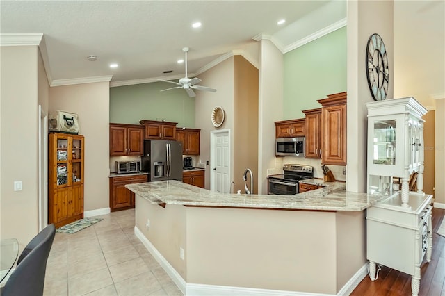 kitchen with light tile patterned flooring, appliances with stainless steel finishes, ornamental molding, ceiling fan, and kitchen peninsula