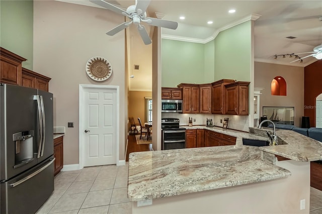 kitchen featuring sink, crown molding, light tile patterned floors, appliances with stainless steel finishes, and kitchen peninsula